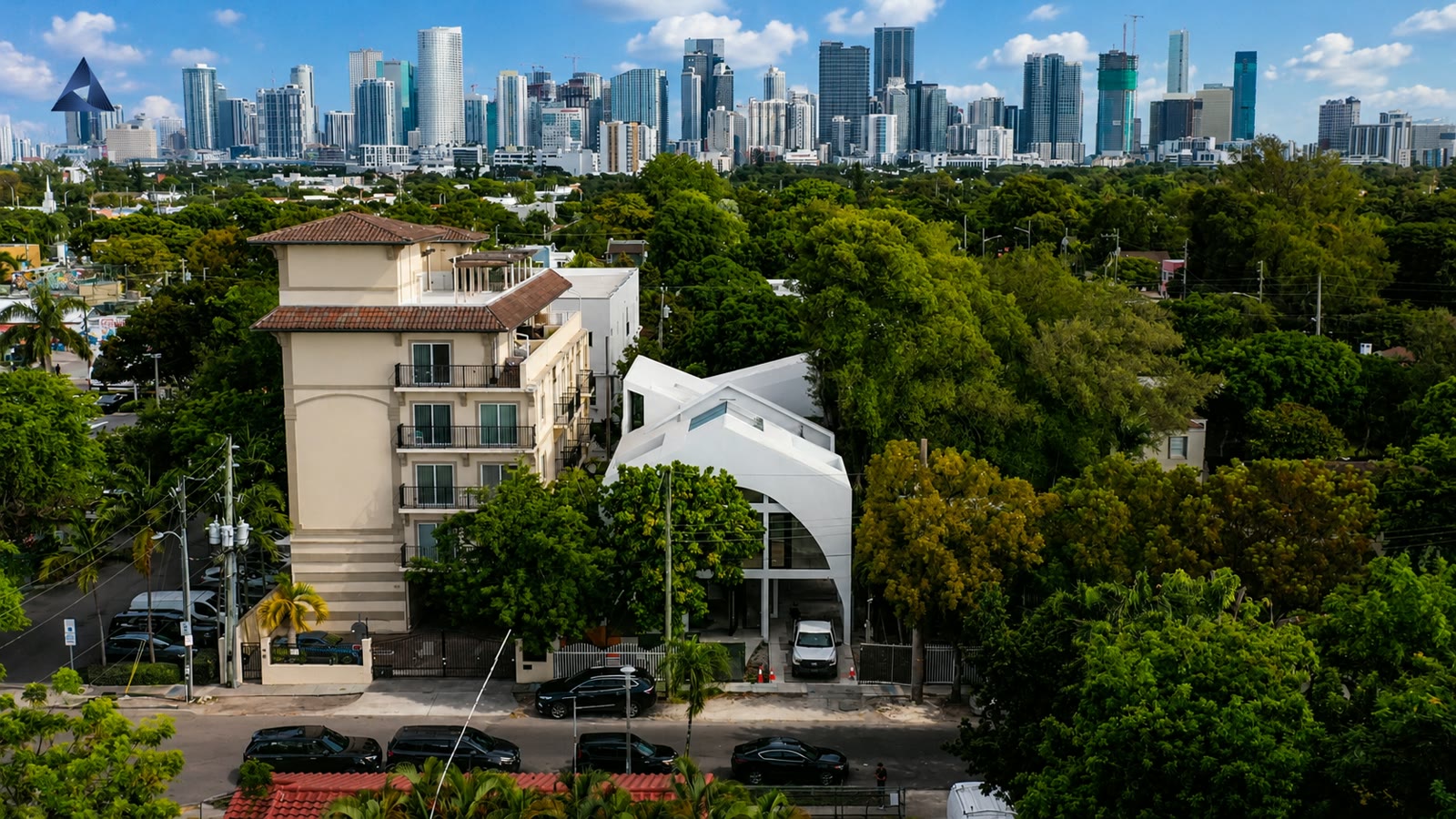 La casa desde muy arriba sobre su calle de Little Havana, pequeña contra el follaje, con el centro de Miami en el horizonte.