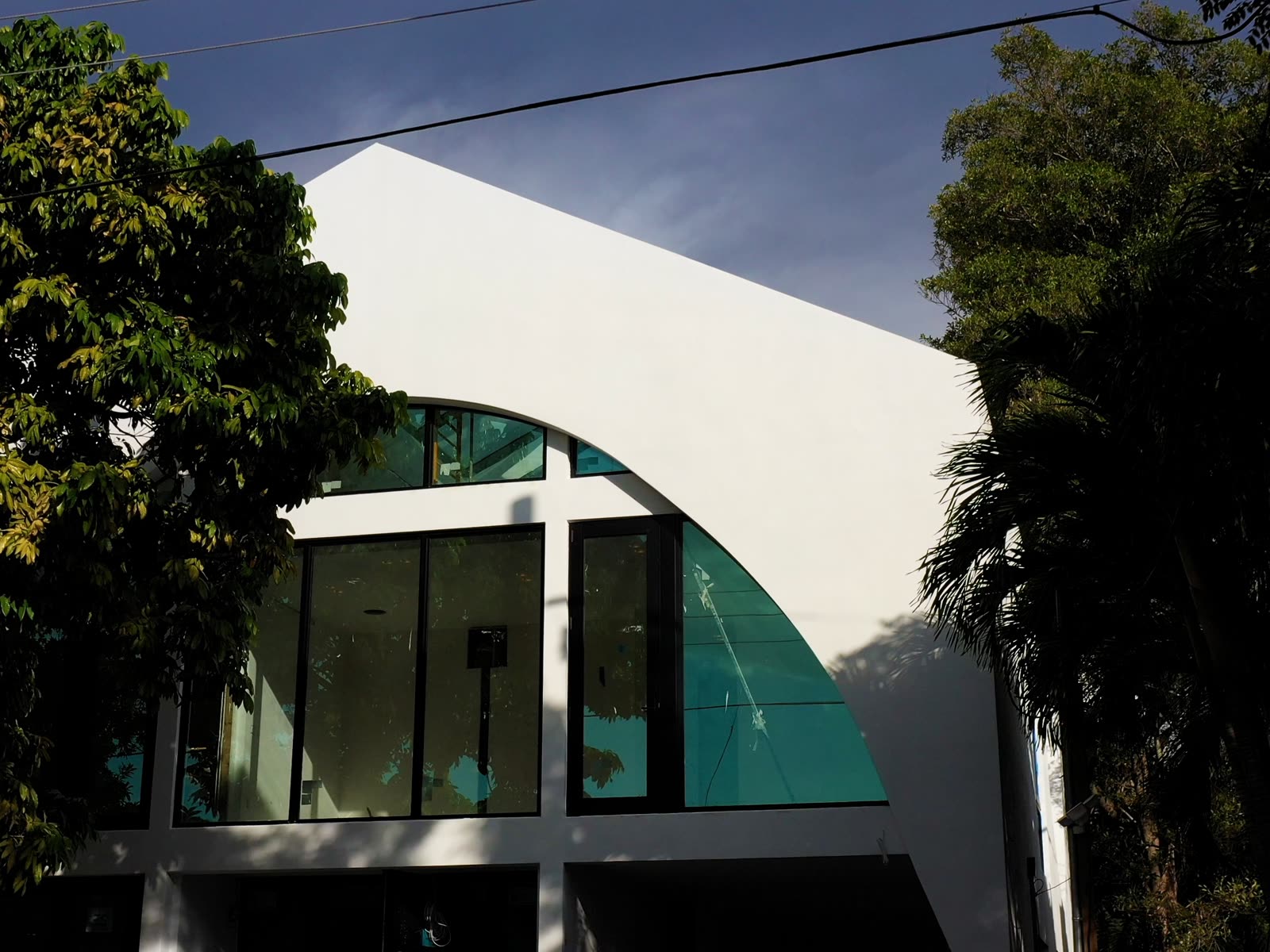 The curved corner. Glass carried around a radius, under a cantilevered white plane.