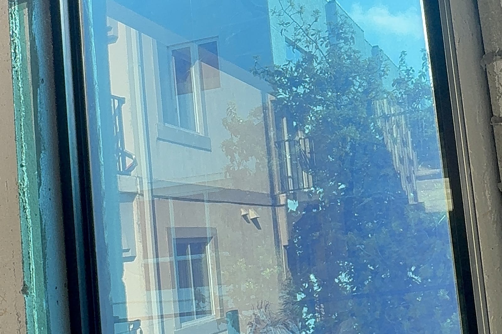 Installed and reflecting. The neighboring street reads back off the outer lite.