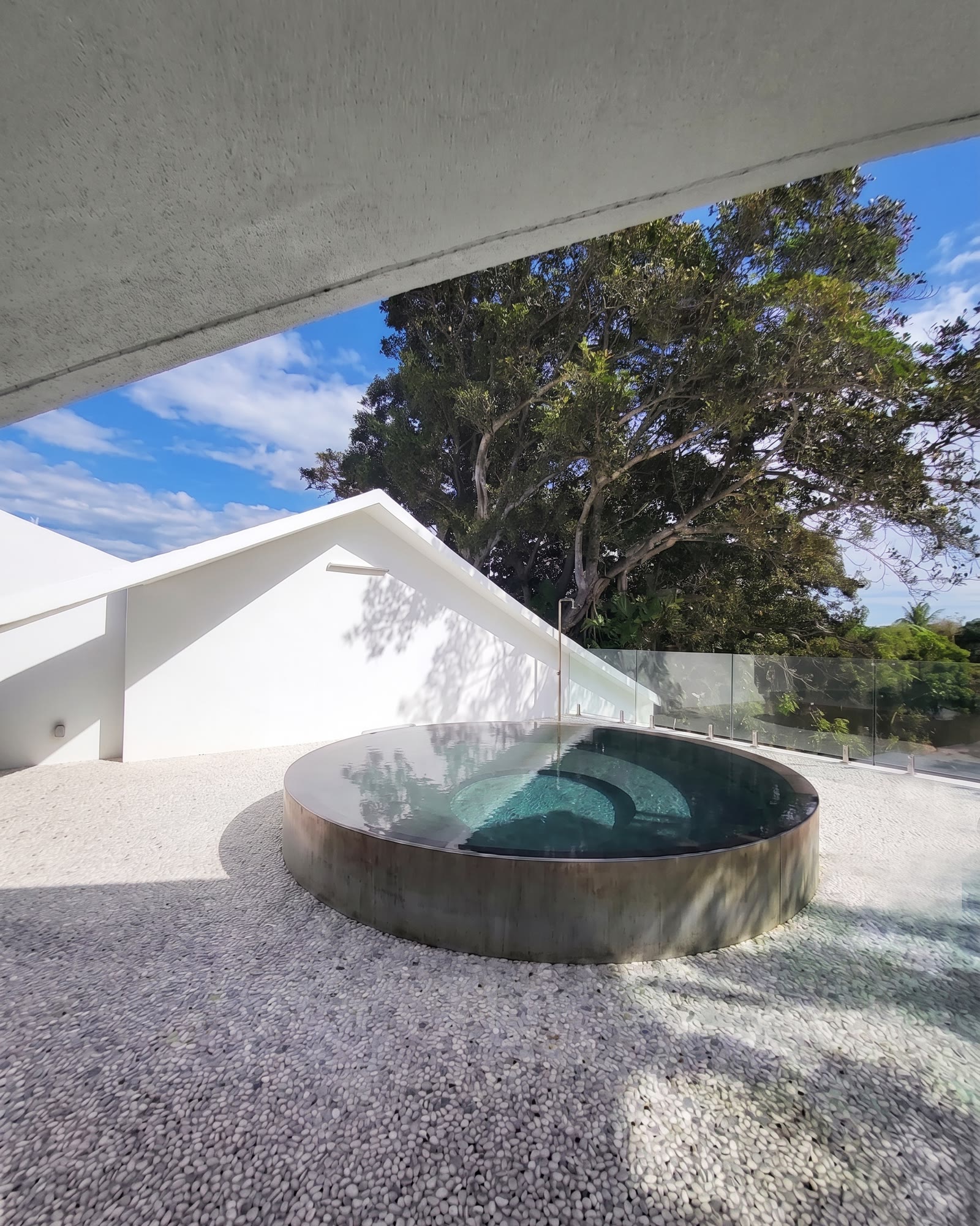 El disco azul del cuarto diagrama, construido: la piscina embutida en la cubierta con el sofito curvo cerrándose sobre…