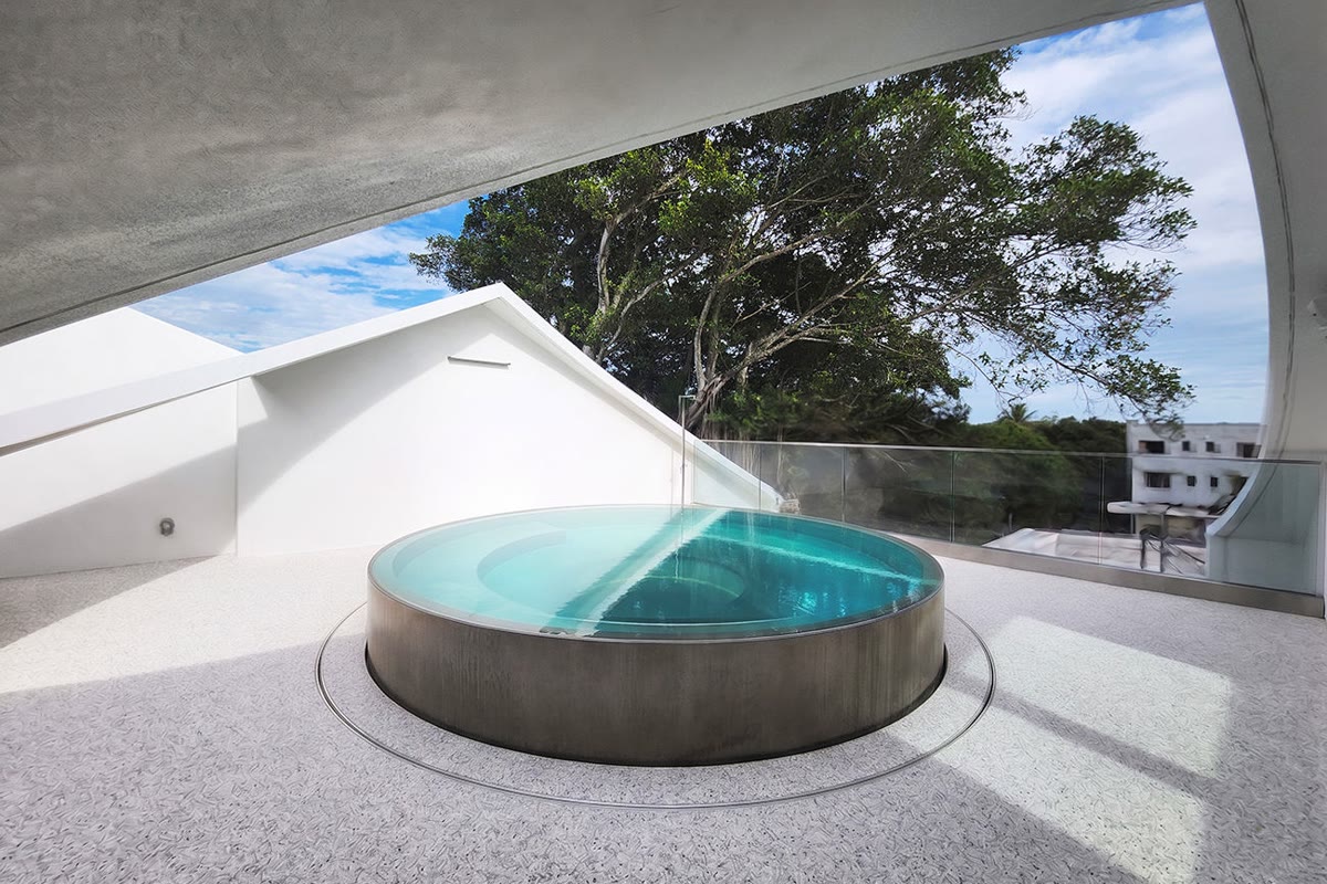 The stainless steel vessel set into the roof terrace, the curved soffit overhead.
