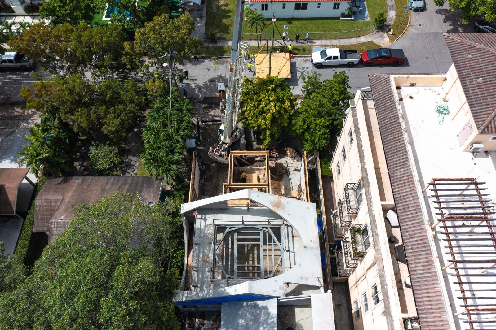 El levante, desde arriba. Un elemento precolado despejado del camión con la calle cerrada debajo.