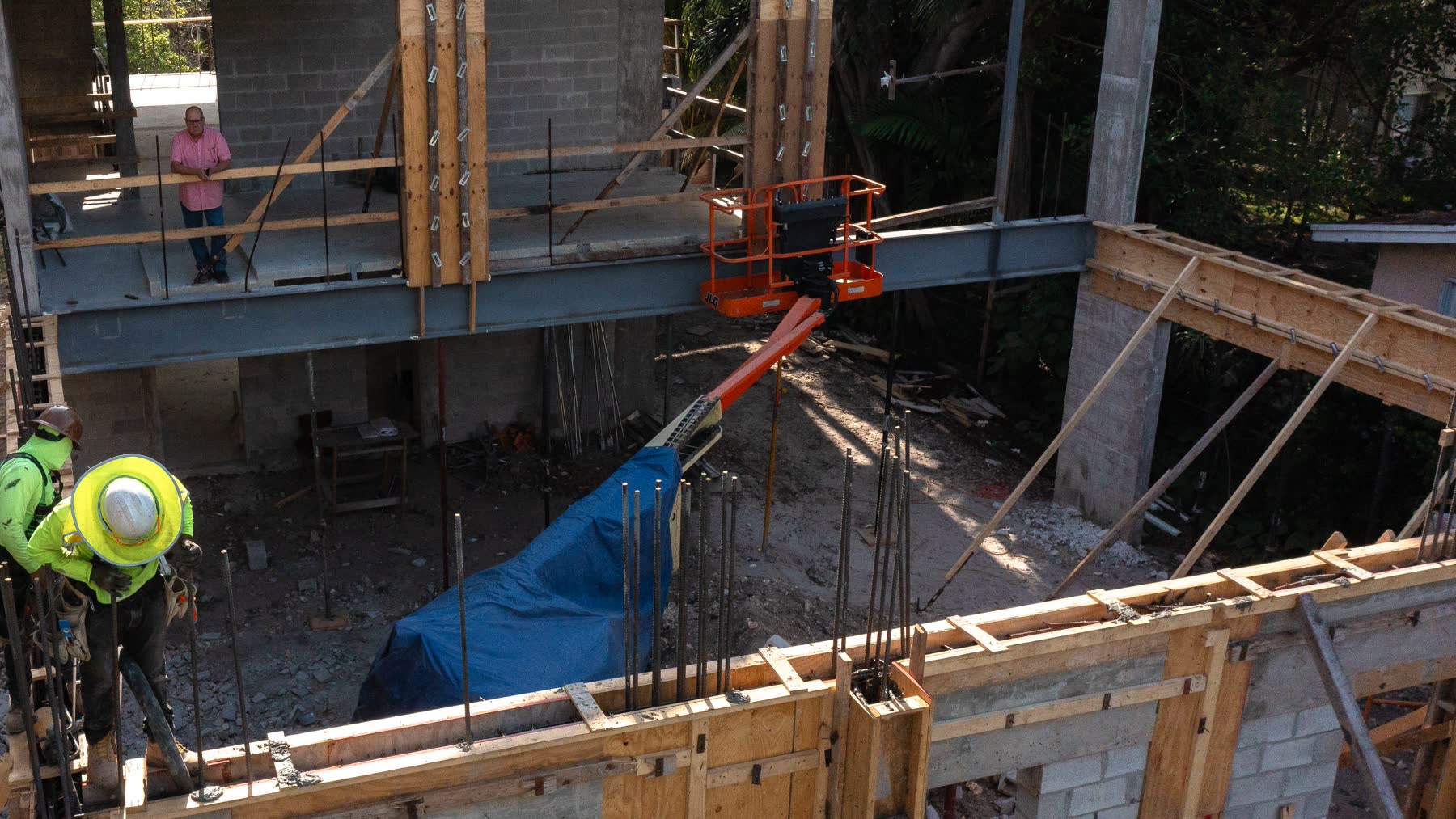 Acero estructural posado sobre el marco de concreto y bloque. Estas vigas cargan los claros largos que la mampostería…