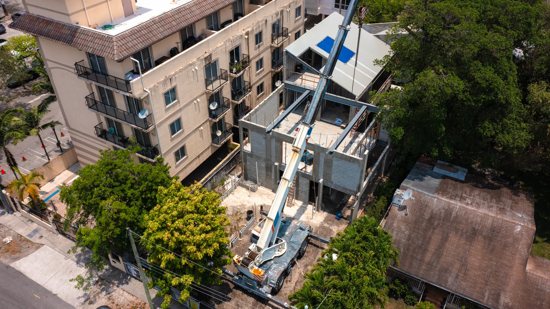The crane rigged in the street, working over the neighboring building. Sequencing this lot was the job.