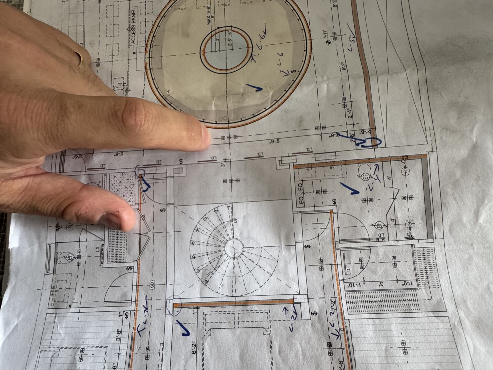 The circular stair drawing on the plan set, a hand tracing the geometry.