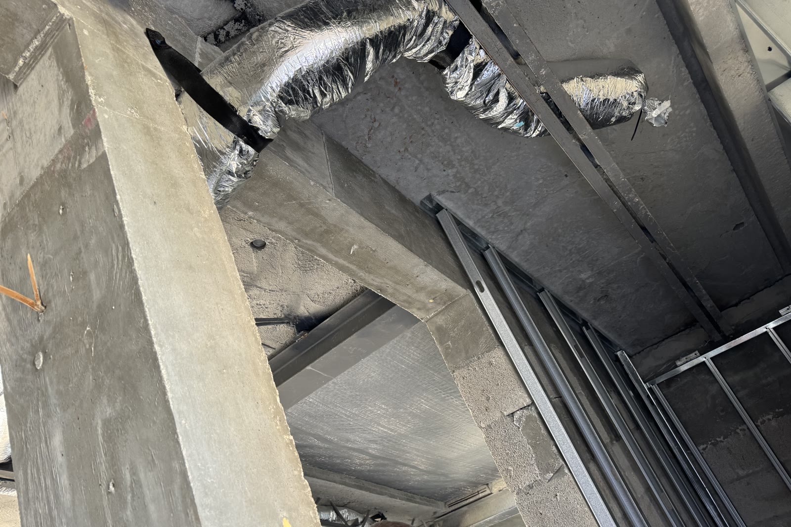 Aire ducteado a través de la estructura. Ramales flexibles aislados saliendo de un troncal rígido dentro del techo…