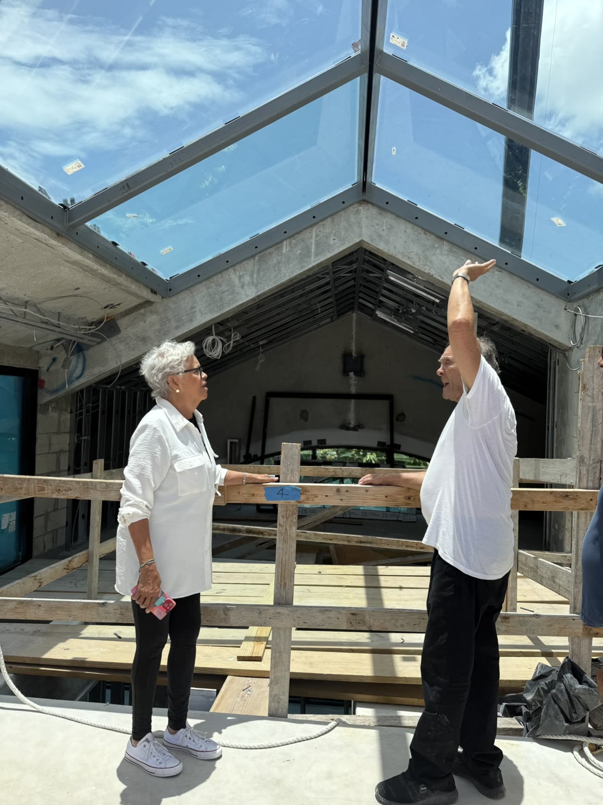 Terry y Leslie bajo el tragaluz de vidrio, en la losa en medio de la construcción.